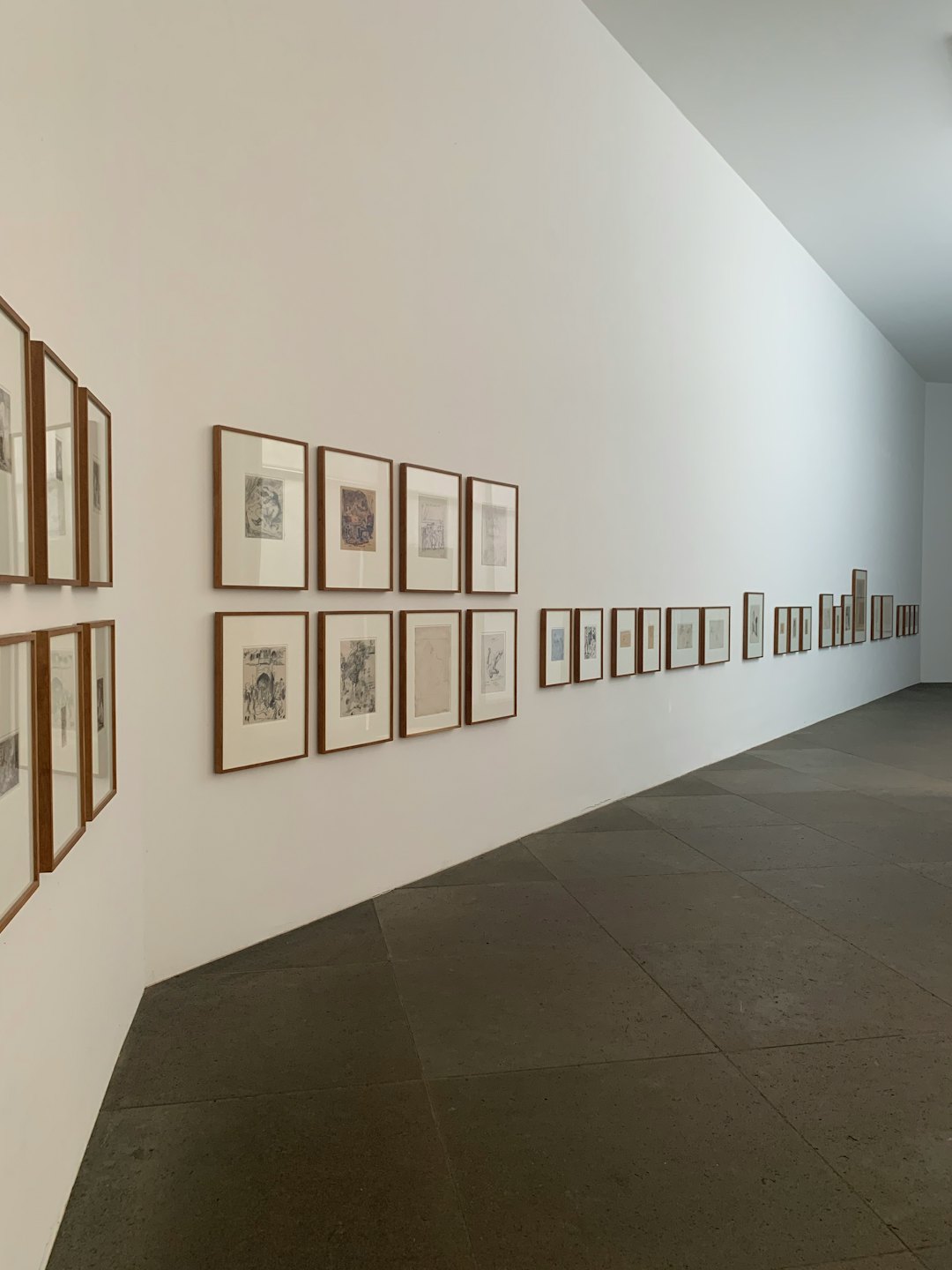 Modern art gallery corridor with framed artworks on the walls.