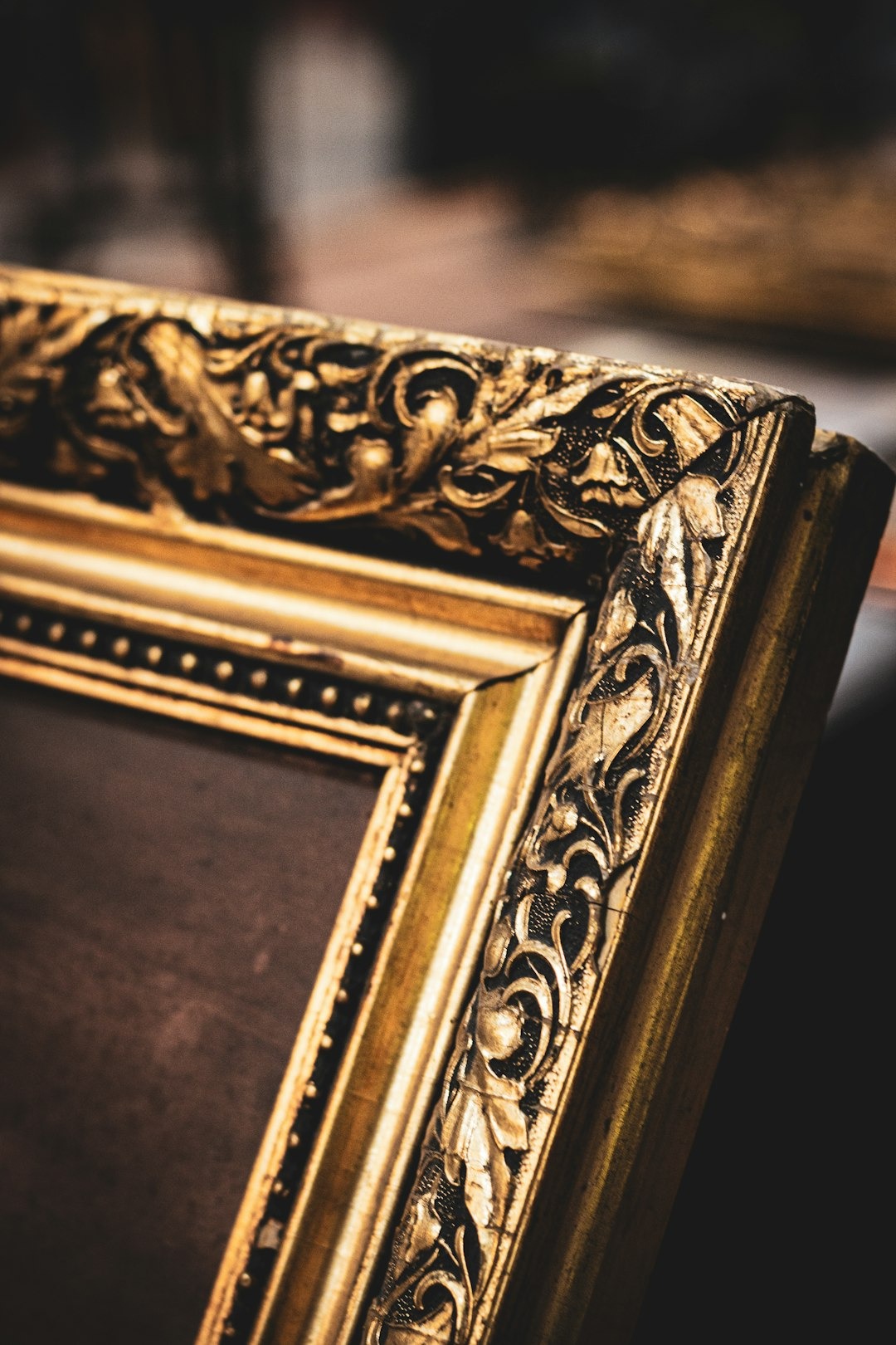 Intricately carved golden antique picture frame corner.